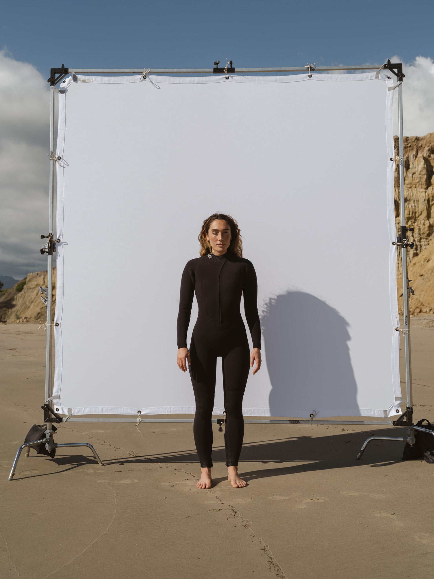 Zoomed out view of women’s black 4/3mm Jersey front-zip wetsuit by Basalt